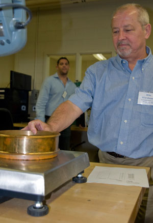 Mike Wierzbowski, of Westland Plastics in Winnipeg, Manitoba, measures the weight of a specific particle size for polyethylene powder during a material-grinding experiment.