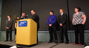 Kyle M. Pfueller, right at podium, passes the gavel (and the SGA presidency) to Adam J. Yoder, elected to lead the organization in 2010-11. Pictured in the background are, from left, Louis J. Lowther, 09-10 vice president for internal relations%3B Ashlyn M. Hershberger, re-elected as vice president for public relations%3B Gregory J. Miller, 2010-11 vice president for internal relations%3B Randy A. Kuhar, 2010-11 vice president for finance%3B and SGA adviser Sara R. Hillis, assistant director of student activities for student services and involvement. 