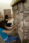 Girls use skill and creativity to affix fabricated stone to a 