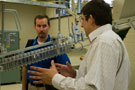 A Penn College student, right, answers questions about production of plastic bottles in the college's blow-molding lab.