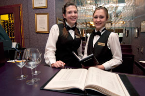 Pennsylvania College of Technology students Hannah E. Fisher, left, of Red Hook, N.Y., and Rachel M. Emmons, of Washington, N.J., train at beverage service in the college%E2%80%99s fine-dining learning lab, Le Jeune Chef Restaurant. The two were selected to represent Penn College at the National Restaurant Association%E2%80%99s Salute to Excellence.