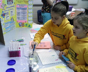 Sisters participate in an interactive lesson about keeping teeth healthy.