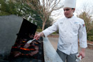 Richard J. McGlynn, of Drums, a culinary arts and systems student, tends to the grill on the Thompson Professional Development Center patio