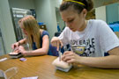 Two campers practice their suturing skills in the surgical technology lab