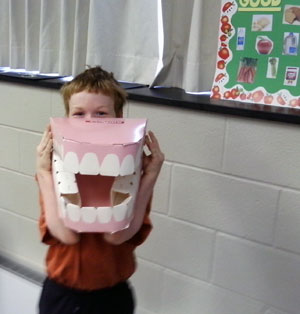 A child tries on a pair of giant teeth in the education room set up by dental hygiene students.