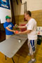 Volunteer assistant cross-country coach Jeff Faherty accepts a canned-food item from student Dylan Lackey, handing out a mini-throwball in return