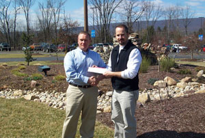 Fred Barberra, right, of ValleyCrest Landscape Maintenance, Norristown, presents a %24750 check to Carl J. Bower Jr., a member of Pennsylvania College of Technology%E2%80%99s horticulture faculty, near the main entrance to the college%E2%80%99s Schneebeli Earth Science Center.
