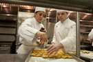 LaRosa adds salt to the panelle being trayed by culinary arts and systems student Phillip D. Poliniak