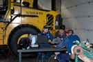 A three-member team of technicians troubleshoots 'bugs' in an L110F wheel loader
