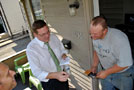 Scott E. Kennell, director of athletics (left), and Strickland greet an off-campus tenant