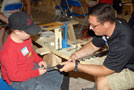 Walter J. Shultz, director of instructional technology and distance learning, helps Kyle Ulmer assemble his derby entry