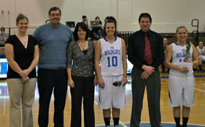 Assistant women's basketball coach Erica Logan joins team members Kierstin Steer (10) and Samantha Wallish and their parents for a senior tribute