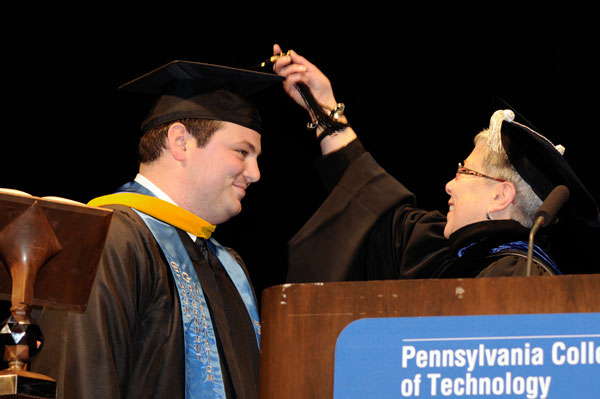 Adam J. Yoder's transition from student to alumnus is completed with a presidential turn of the tassel.