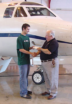 Kyle E. Laughman receives a scholarship check from James E. Doebler, associate professor - and department head - of aviation, at the Lumley Aviation Center. (Photo by Brett A. Reasner, associate professor of aviation)