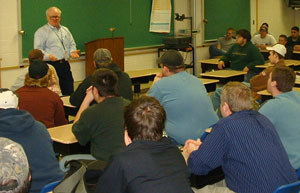 Jim Clark, manager of training at Aker Philadelphia Shipyard, talks with welding students.