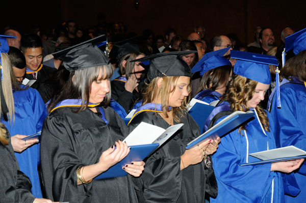 Students follow the college's alma mater through lyrics in the commencement program.