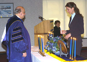 Jennifer L. Fritz lights her candle and prepares to deliver the Alpha Chi pledge, as co-adviser Irwin H. Siegel presides.
