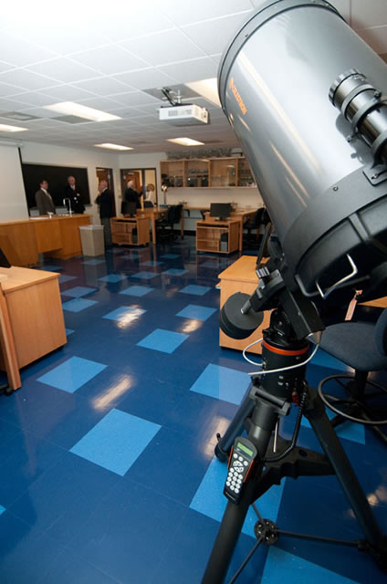 A Celestron telescope stands ready for star-gazing in a classroom. 