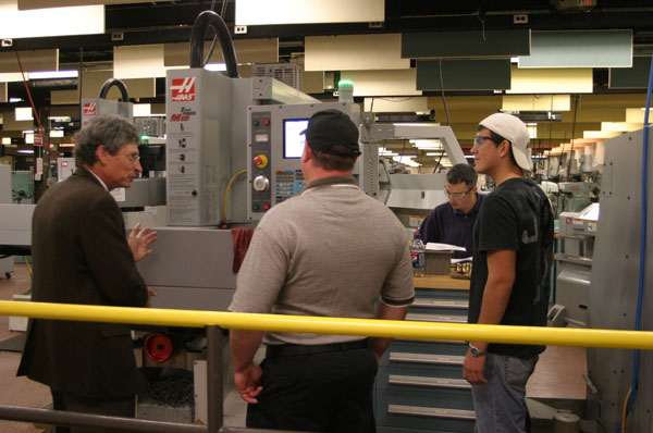 Lynn Turney, an instructor in machine tool technology/automated manufacturing technology, with visitors to College Avenue Labs.