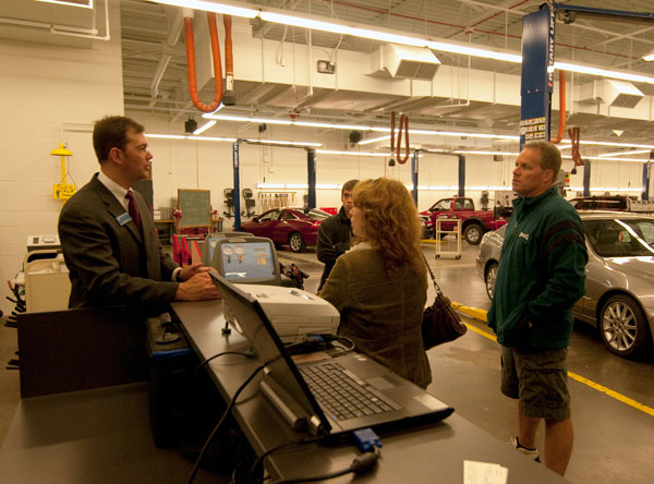 Chris J. Holley, assistant professor in automotive, meets with Open House attendees in the lab.