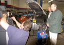 Jeffrey M. Januchowski, left, instructor of automotive technology (Ford ASSET), demonstrates equipment for American Welding Society President Gerald D. Uttrachi, right, who toured the School of Transportation Technology with Colin W. Williamson, school dean.