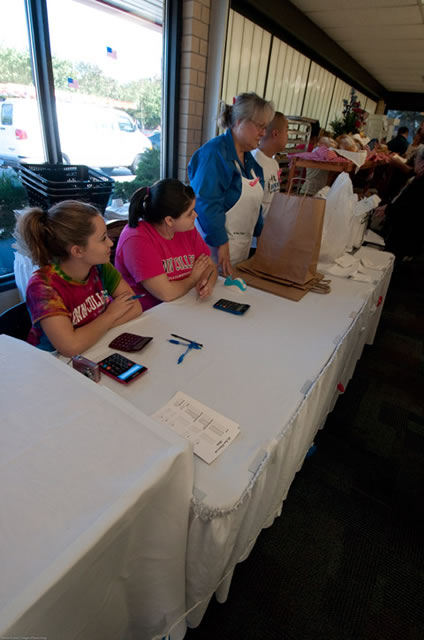 Bake sale managers Haley Shuman (left) and Catie Zimmerman join Chef Monica Lanczak (standing) for Friday's Homecoming "American Regional" bake sale at The Market.