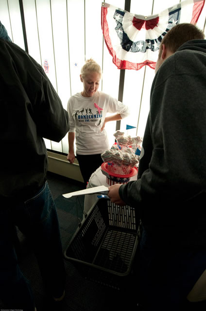 Under a splash of Old Glory, student Lauren Hammer helps bake-sale patrons make their selections.
