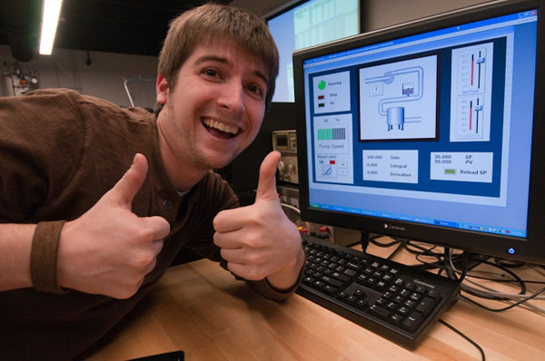 Mark A. Vasellas, an electronics and computer engineering technology major making a presentation during Open House, signals his enthusiasm prior to crowd's arrival.