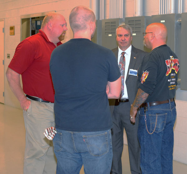 David R. Cotner, instructor of welding (in red shirt) and William E. Mack, assistant dean of industrial and engineering technologies, talk with Saturday guests at the MTC.