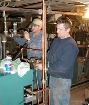 Second-year students Bruce R. Tami (left) and Chad E. Hoffer help in boiler installation.