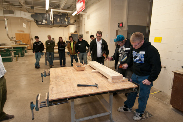 Career Day guests compete in a nail-driving contest, sponsored by the School of Construction and Design Technologies.