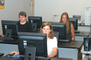 Clockwise from foreground, Susan B. Deuel, technical support manager%3B and Christine E. Atkins and Lolita R. Mohney, technical support analysts, put the final pre-semester touches on a lab at Pennsylvania College of Technology's Business and Technology Resource Center.