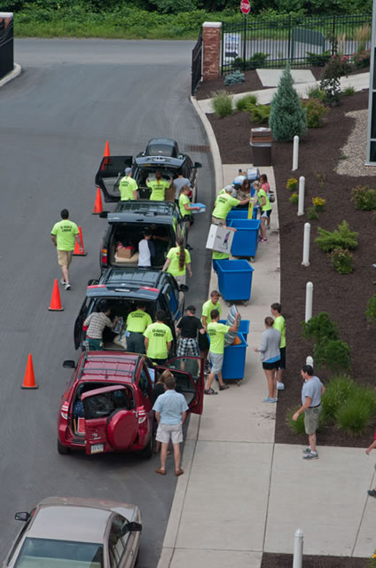 Crews converge on family vehicles, quickly emptying contents into apartment-bound bins.