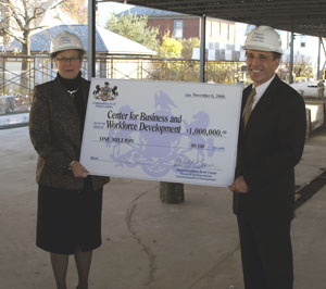 Penn College President Davie Jane Gilmour accepts a %241 million check from state Rep. Brett O. Feese toward completion of The Center for Business and Workforce Development.