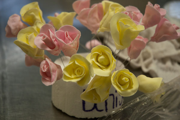 Roses await placement on a contest cake.