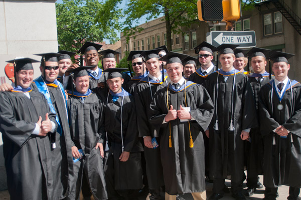 Candidates for bachelors degrees in building automation technology gather for a group photo during a pause in the procession.