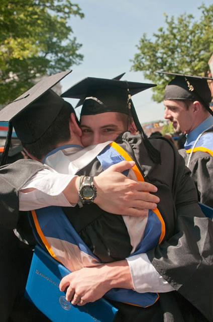 Graduates share a congratulatory moment.