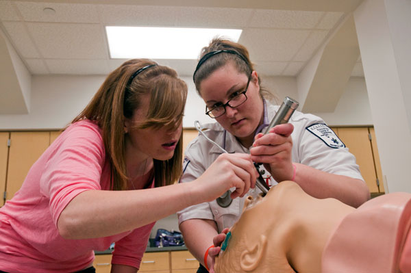 A student from Indiana County Technology Center inserts a tube into the trachea of a manikin.