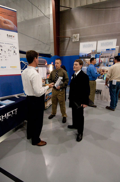 A representative of the Maryland-based Prichett Controls Inc. talks with students in the Field House.