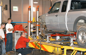 An instructor from Chief Automotive Systems shows participants to use the EZ Liner to straighten a truck frame.