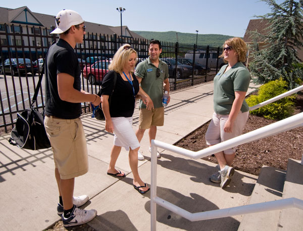 Green-shirted student Links  Andrew R. Christoffel and Kelly A. Bensinger  provide personalized attention outside student housing.
