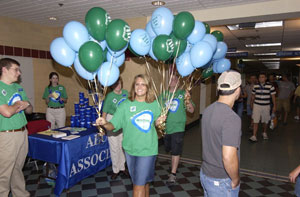 Courtney R. Held, SASC services specialist, carries %22Just Ask Me%22 balloons through the Bush Campus Center during Friday's start of Fall 2004 Orientation. (Photo by Joseph S. Yoder, News Bureau manager)