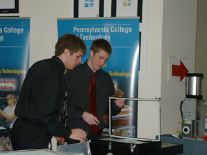 Students Daniel M. Dietrich, Nazareth (left), and Ashlin R. Hollinger, Columbia, offer hands-on activities using a plastics vacuum thermoformer at Career and Technical Education Week events in Harrisburg. (Photo by Stacey C. Hampton, coordinator of matriculation and retention, School of Industrial and Engineering Technologies)