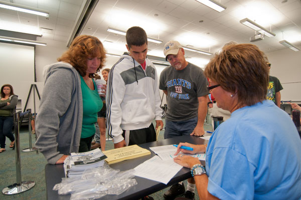 Dana R. Suter, coordinator of part-time student employment and career programming, goes over the Welcome Weekend schedule for a freshman and his parents.
