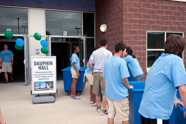 A "bucket brigade" of blue-shirted volunteers coordinates first-year arrivals' move to Dauphin Hall, the college's newest on-campus student housing option.