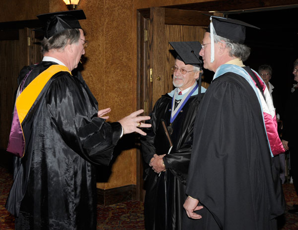 William J. Martin, senior vice president (left), engages faculty speaker Dennis F. Ringling (center) and James E. Temple, commencement marshal, in animated discussion.