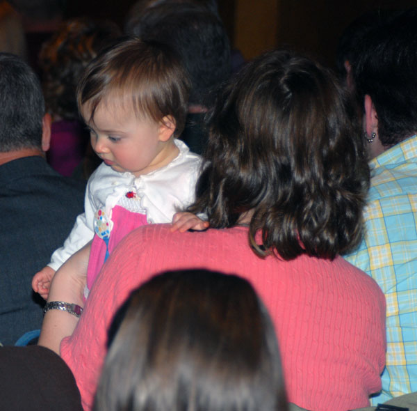 A young attendee is distracted from the official action onstage.