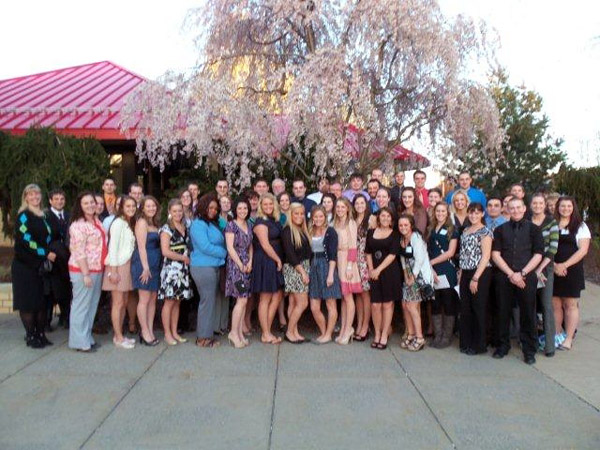 Fashionable for any occasion, Etiquette Dinner guests join their mentors for a group photo outside Le Jeune Chef Restaurant.