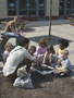 Outside the Campus Center, students Jason R. Grottini and Adrianne R. Watkins show children how to plant white-oak trees