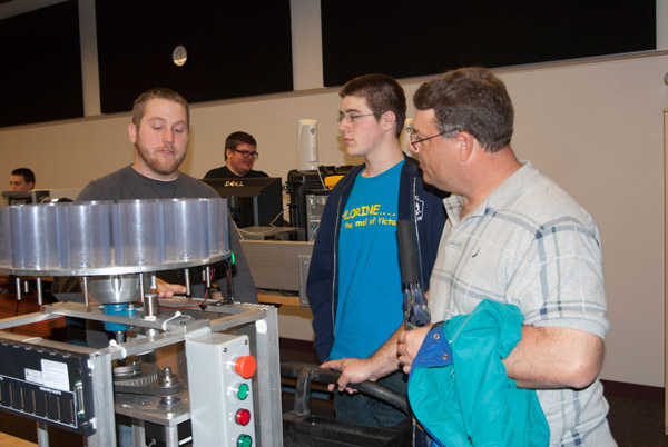 Frank M. Daugherty, of Brogue, a sophomore in the electronics and computer engineering technology: robotics and automation emphasis major, shows his project  programming a step motor  to a pair of visitors. Students in electronics and computer engineering technology classes traditionally develop projects to demonstrate during Open House.